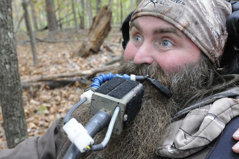 Steve Swope shows how he moves a small lever with his mouth to aim his crossbow. At right is a mouthcontrolled trigger he bites to shoot the crossbow.