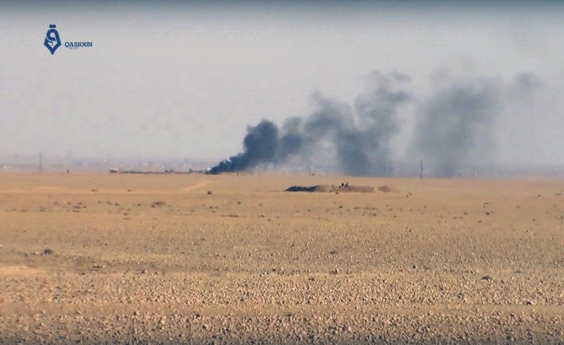 This frame grab from video provided by Qasioun a Syrian opposition media outlet, shows smoke rising as a result of clashes between U.S.-backed forces and the Islamic State group, near Ein Issa, north of Raqqa, Syria. 