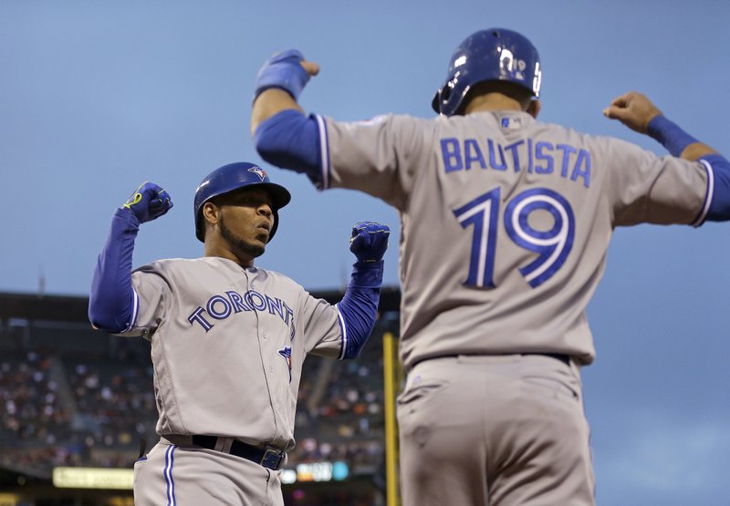 This May 9, 2016 file photo shows Toronto Blue Jays' Edwin Encarnacion, left, celebrating with Jose Bautista (19) after hitting a two run home run off San Francisco Giants' Jake Peavy in the third inning of a baseball game in San Francisco. 
