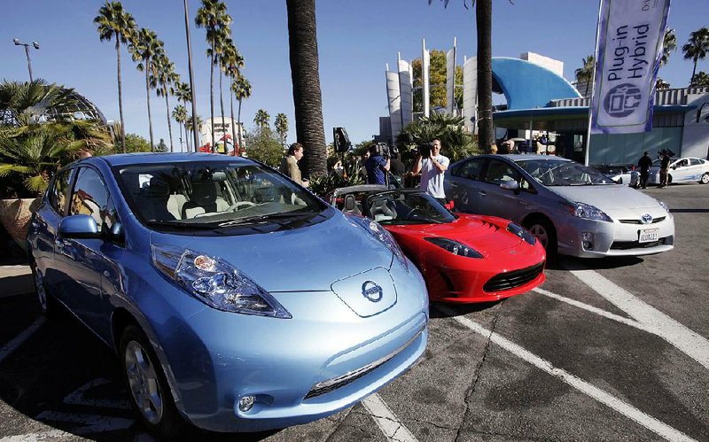 Electric cars from Nissan (left), Tesla and Toyota are presented at a news conference in Los Angeles in this file photo. Consumers favoring trucks and sport utility vehicles over fuel sippers such as the Prius hybrid are forcing Toyota and Nissan to adjust sales expectations. 