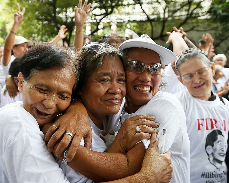 Supporters of the late Philippine dictator Ferdinand Marcos celebrate shortly after the Philippine Supreme Court voted 9-5 with one abstention Tuesday to allow Marcos to be buried at the heroes cemetery in in Taguig City, Philippines. 
