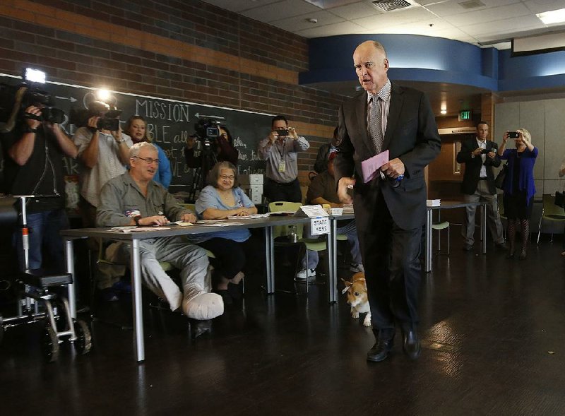 California Gov. Jerry Brown deposits his mail-in ballot at a site in Sacramento on Tuesday. In the final weeks of the elections, Brown made a last-minute push for Proposition 57 to make more state prisoners eligible for parole and against Proposition 53, which would require voter approval for the sale of revenue bonds of $2 billion or more.