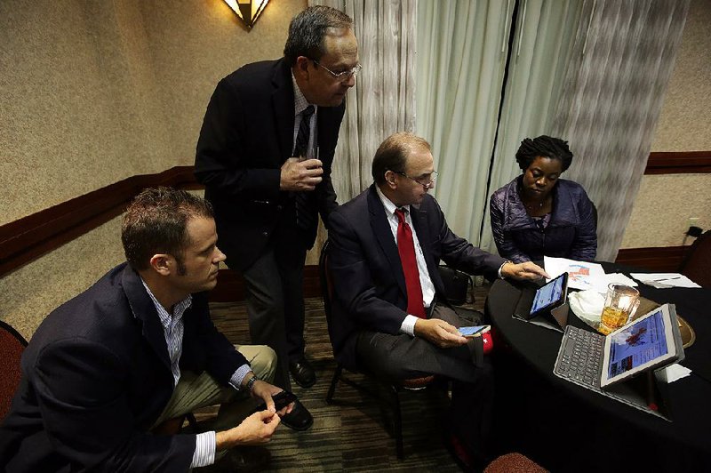 Issue 6 opponents (from left) Kevin Russell, Jerry Cox, Kenny Hall and Charisse Dean look at election results during a gathering Tuesday at the Embassy Suites in Little Rock.