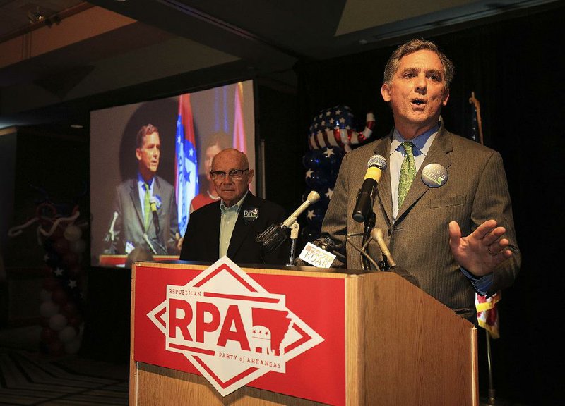 Jay Hill (left) stands by Tuesday night as his son, incumbent U.S. Rep. French Hill, address supporters during a Republican watch party in Little Rock. Hill won handily, according to unofficial results.