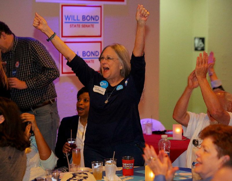 Judy Robinson of Little Rock celebrates as early presidential returns appear on the television during a Democratic Party gathering Tuesday evening in downtown Little Rock.