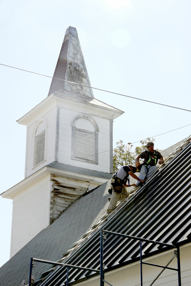 LYNN KUTTER ENTERPRISE-LEADER Cumberland Presbyterian Church in Prairie Grove gets a new standing seam metal roof. The former church is being renovated to be used as a wedding chapel.