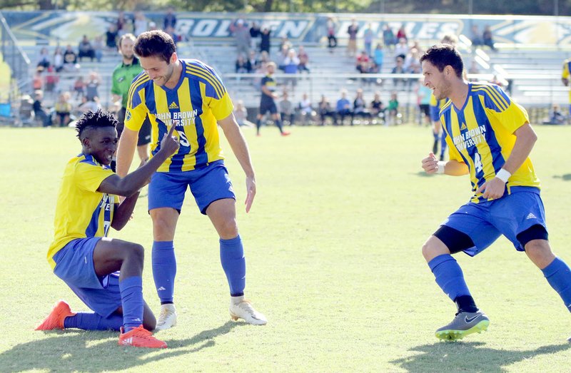 Photo courtesy of JBU Sports Information John Brown University soccer players, from left, Kelvin Omondi, Santiago Vanegas and Daniel Marulanda celebrate after Omondi scored a goal Saturday in the Golden Eagles&#8217; 2-0 win against Texas Wesleyan in the quarterfinals of the Sooner Athletic Conference Tournament.