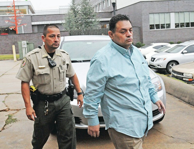 NWA Democrat-Gazette/FLIP PUTTHOFF Mauricio Torres (right), 45, is escorted Nov. 8 into the Benton County Courthouse annex in Bentonville.