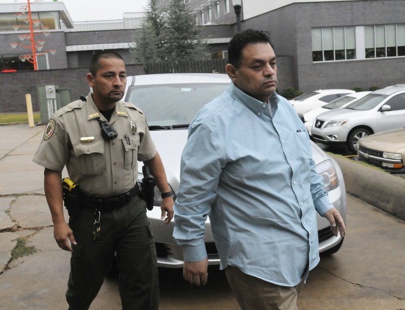 Mauricio Torres (right), 45, is escorted into the Benton County Courthouse annex in Bentonville in this file photo.