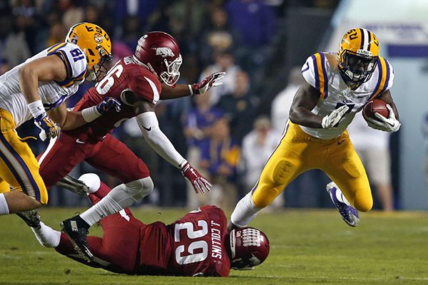 LSU running back Leonard Fournette (7) is tackled by Arkansas defensive back Jared Collins (29) and defensive back Rohan Gaines in the first half of an NCAA college football game in Baton Rouge, La., Saturday, Nov. 14, 2015. (AP Photo/Gerald Herbert)