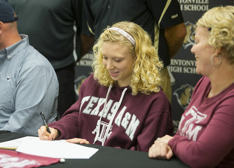 Taylor Pike signs her letter of intent with Texas A&M on Wednesday following a signing ceremony at the Bentonville High School Tiger Athletic Complex.
