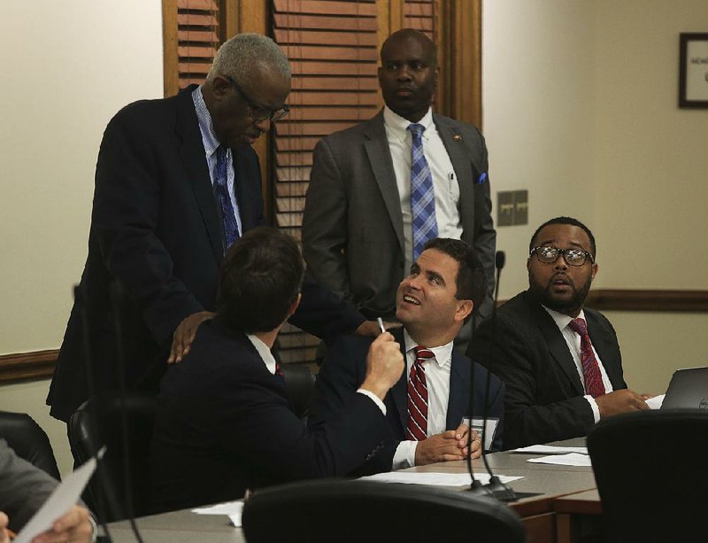 House Democrats representing Little Rock talk Thursday before the start of their district caucus meeting. Standing are John Walker (left) and Fred Love. Seated from left are Clarke Tucker, Warwick Sabin and Charles Blake. Sabin has gained a seat on the House Revenue and Taxation Committee. 