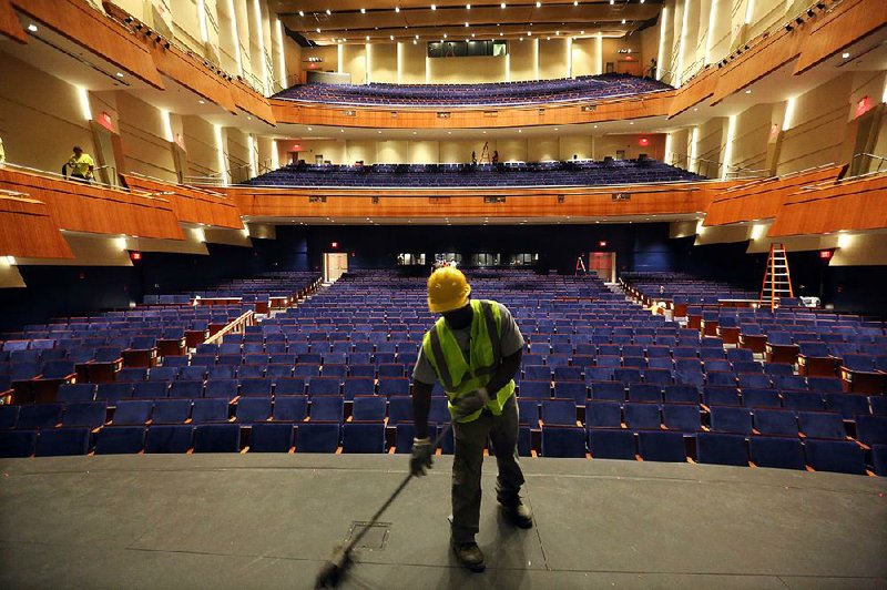 Weldon Foxworth cleans the stage at Robinson Center in Little Rock before the unveiling of the renovated performance hall and the grand ballroom Thursday after “a 28-month intermission.” 
