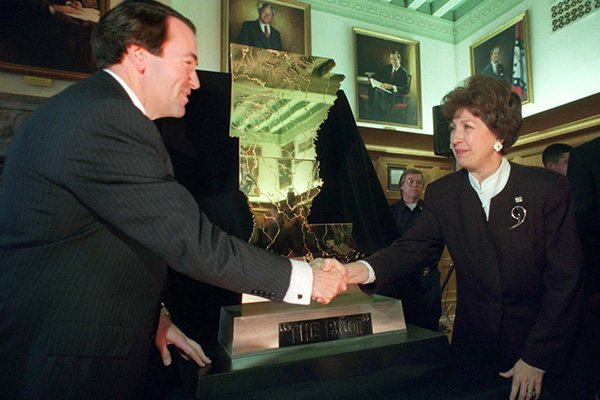 Arkansas Gov. Mike Huckabee, left, shakes hands with Louisiana Lt. Gov. Kathleen Blanco after they unveiled The Boot trophy at Huckabee's office in Little Rock on Wednesday, Nov. 27, 1996.