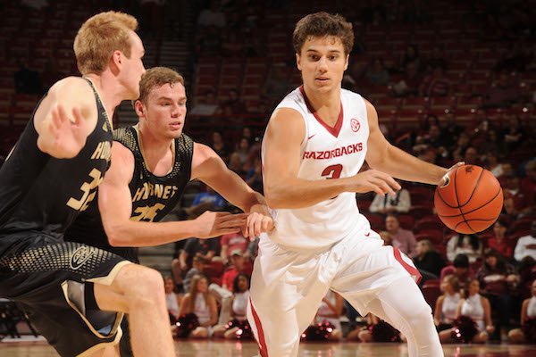 Arkansas' Dusty Hannahs (right) drives around Emporia State's Josh Pedersen (left) and Jack Dale Friday, Nov. 4, 2016, during the second half of play in Bud Walton Arena in Fayetteville.