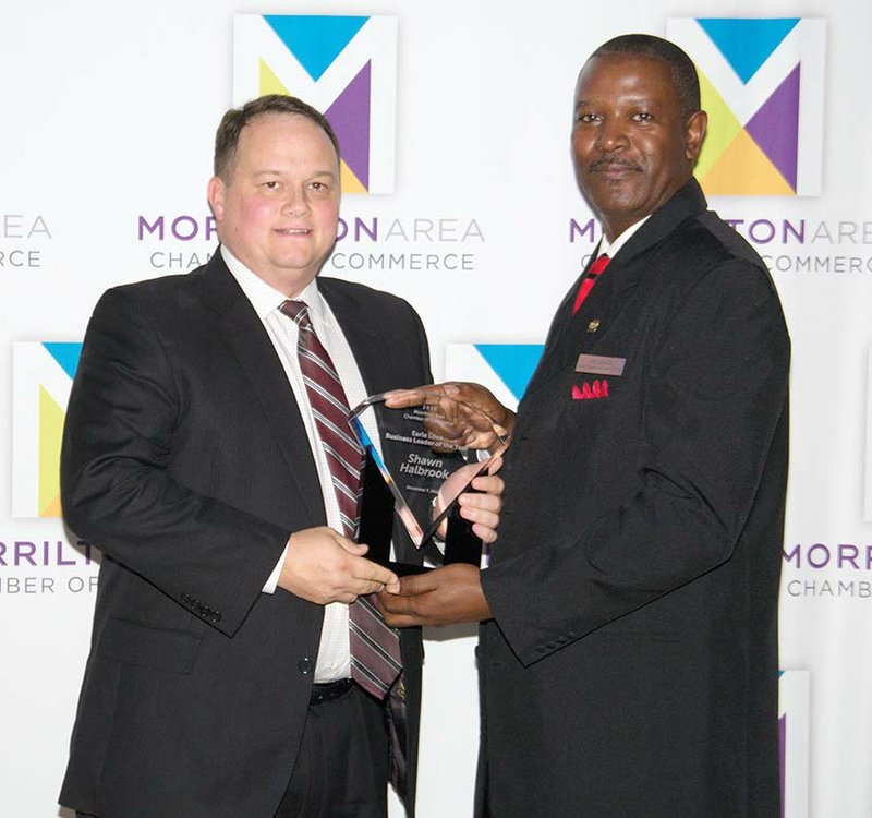Shawn Halbrook, left, superintendent of the South Conway County School District, receives the Earle Love Business Leader Award from Joe Canady, chairman of the Morrilton Area Chamber of Commerce Board of Directors. The chamber banquet was held Monday, and the honor surprised Halbrook.