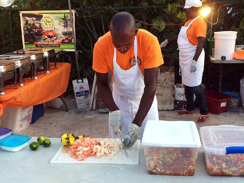 A worker preps food for Grace Bay’s Thursday night fi sh fry in Providenciales, or “Provo,” on the Turks and Caicos Islands.