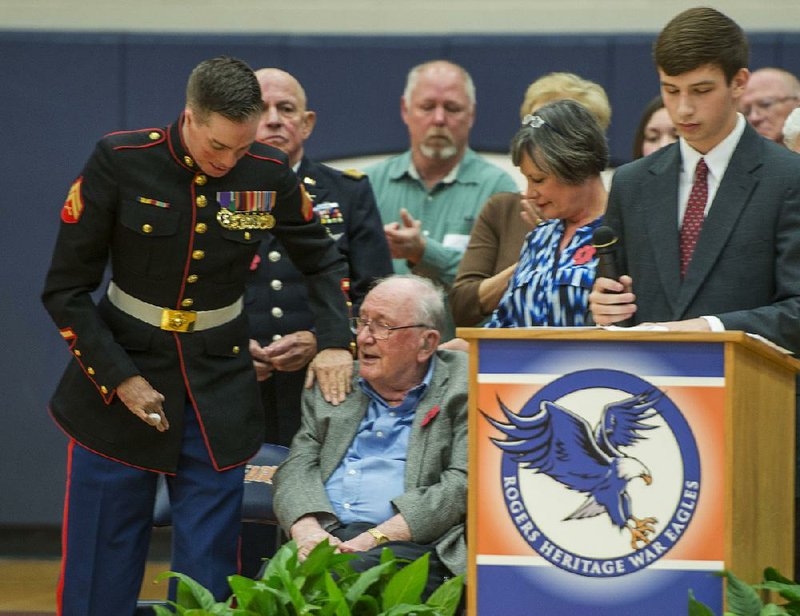 Cpl. Aaron Mankin (left), an alumnus of Rogers High School, acknowledges World War II veteran Jay Jackson on Friday during Heritage High School’s Veterans Day celebration in Rogers. Mankin, a Marine who was wounded in Iraq, was the keynote speaker at the event.