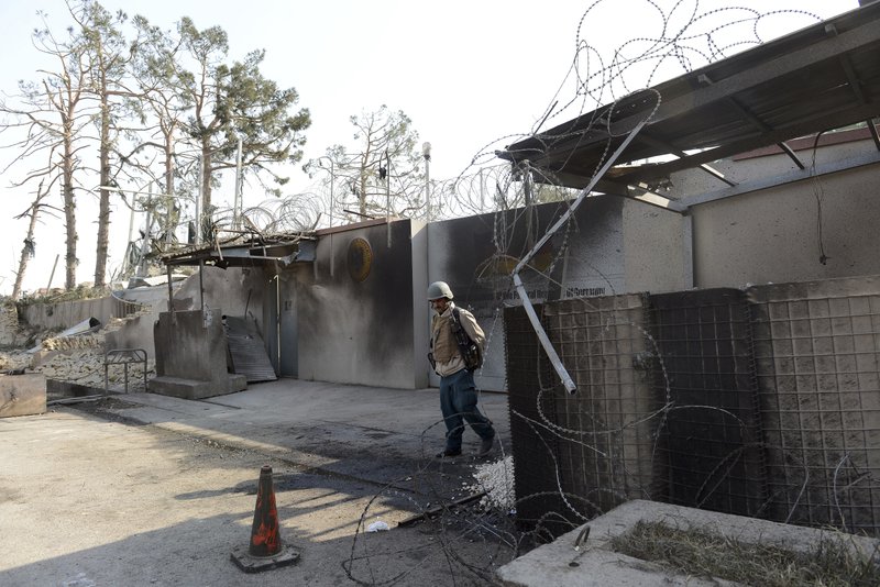 An Afghan security personnel walks at the gate of the German consulate in Mazar-i-Sharif, capital of northern Balkh province, Afghanistan, Friday, Nov. 11, 2016. The consulate was attacked by a suicide car bomber who rammed the compound, killing four people and wounding more than 100, police and a doctor said Friday. 