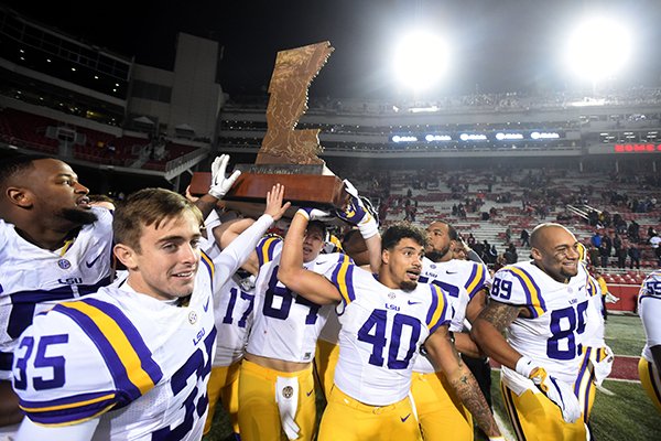 LSU players celebrate with The Boot following a 38-10 win over Arkansas on Saturday, Nov. 12, 2016, in Fayetteville. 