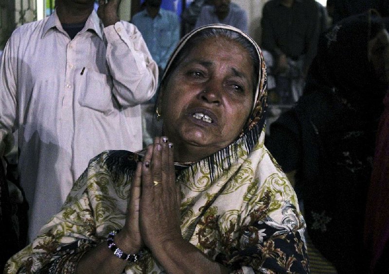 A woman waits outside a hospital emergency ward in Karachi, Pakistan, after Saturday’s bombing at a Sufi shrine.
