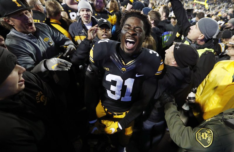 Iowa linebacker Aaron Mends celebrates with fans after an NCAA college football game against Michigan, Saturday, Nov. 12, 2016, in Iowa City, Iowa. 