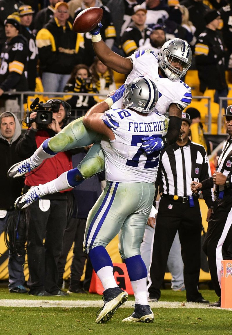 Dallas running back Ezekiel Elliott (top) gets a lift from center Travis Frederick after scoring the game-winning touchdown to lead the Cowboys past Pittsburgh 35-30 on Sunday. Elliott finished with 209 yards of total offense and three touchdowns as Dallas won its eighth game in a row.