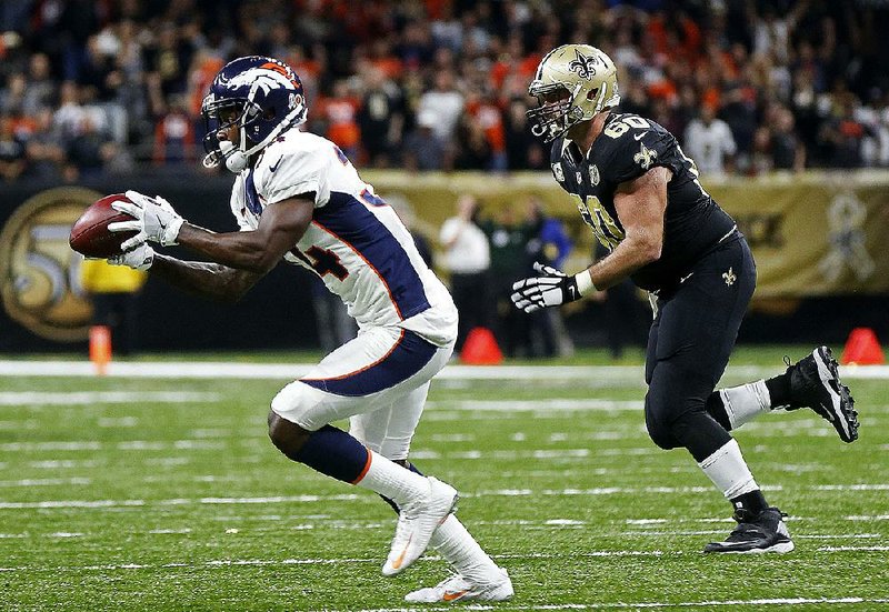 Denver Broncos defensive back Will Parks (34) grabs a blocked extra point and returns it for a defensive two-point conversion as New Orleans Saints center Max Unger (60) pursues late in the fourth quarter Sunday in New Orleans. The Broncos won 25-23.