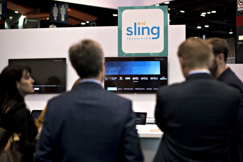 Guests look over products in the Sling Television booth at INTX: The Internet & Television Expo in Chicago, on May 6, 2015. 