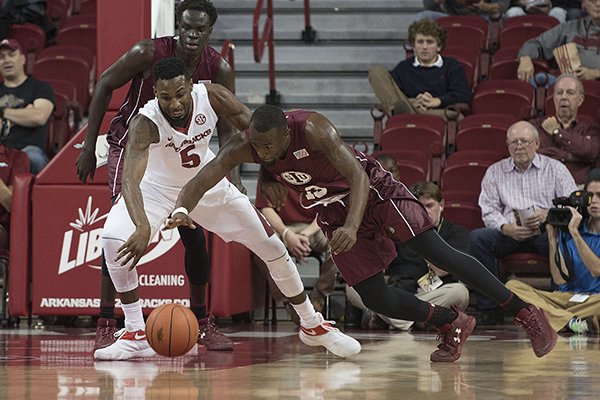 Arkansas' Arlando Cook (left) and Southern Illinois' Sean Lloyd chase a loose ball during the first half Monday Nov. 14, 2016 at Bud Walton Arena in Fayetteville.