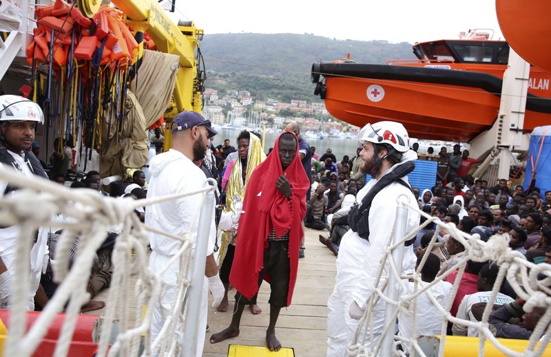 Migrants wrapped in blankets disembark from the vessel Responder, run by the Malta-based NGO Migrant Offshore Aid Station (MOAS) and the Italian Red Cross, in Vibo Valentia, southern Italy, on Monday, Nov. 7, 2016. About 400 disembarked after being rescued at sea in separate operations. 