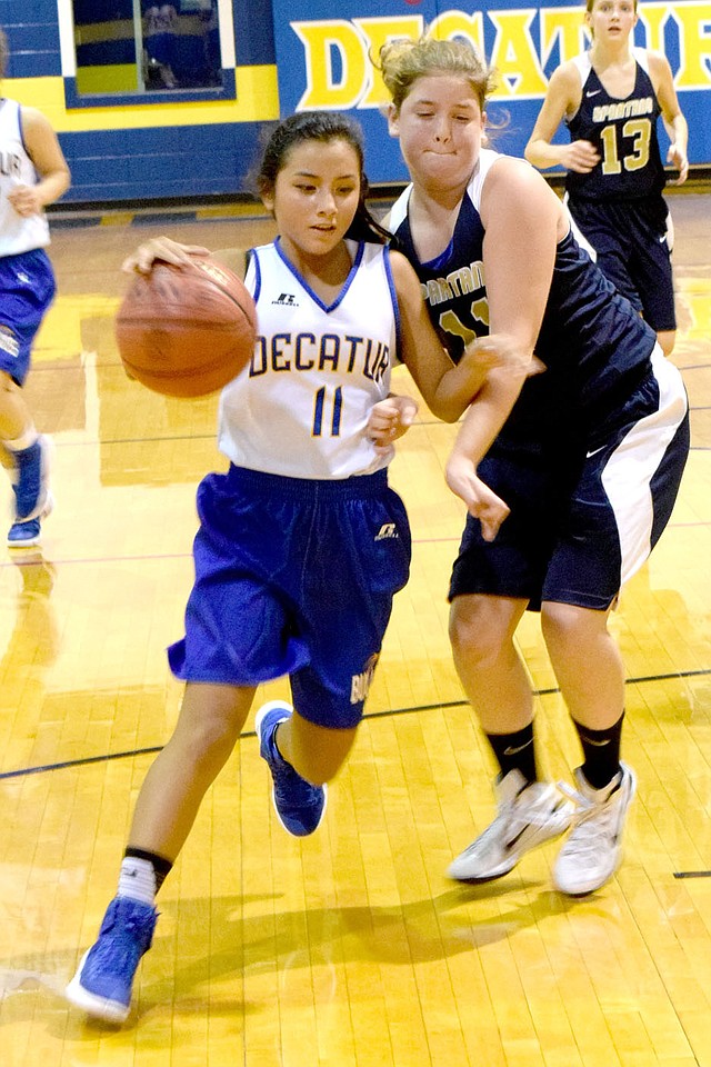 Photo by Mike Eckels Kaylee Morales (Decatur 11) dribbles around a Spartan player during the Nov. 11 Decatur-NWA Classical Academy junior high basketball game at Peterson Gym in Decatur. The junior Lady Bulldogs took victory in its second game of the season, 28 to 19.