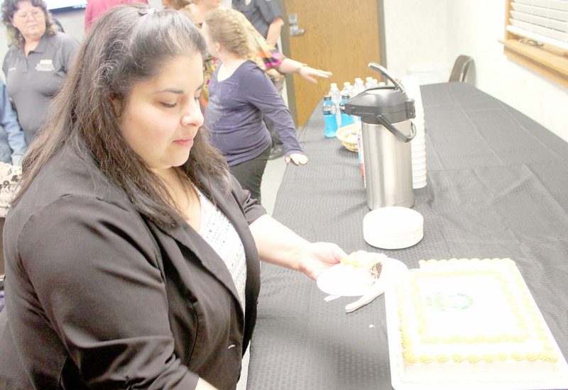 Keith Bryant/The Weekly Vista Shelly Frederick, secretary for the Bella Vista Police Department, cuts the first slice of cake to serve at the Citizens Police Academy graduation.