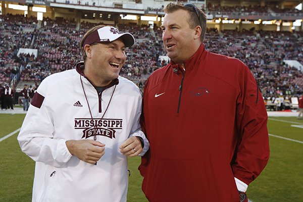 Mississippi State football coach Dan Mullen, left, and Arkansas football coach Bret Bielema confer prior to their teams meeting in an NCAA college football game in Starkville, Miss., Saturday, Nov. 1, 2014. (AP Photo/Rogelio V. Solis)
