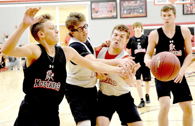 PHOTO BY RICK PECK Boston Dowd, Grant Cooper and Cole DelosSantos (left to right) go for a loose ball during a scrimmage held Nov. 11 during Winter Sports Mustang Pride Day at McDonald County High School.
