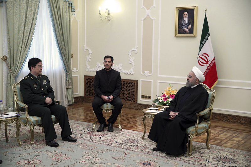 In this photo released by an official website of the office of the Iranian Presidency, President Hassan Rouhani, right, meets with Chinese Defense Minister Chang Wanquan, left, at his office, in Tehran, Iran, Tueday, Nov. 15, 2016. An unidentified interpreter sits at center. 