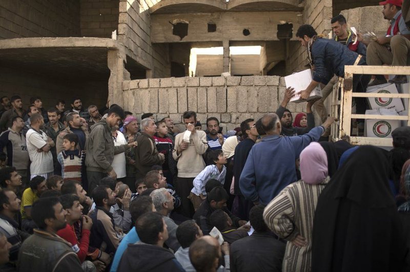 Residents gather to receive food supplies being distributed Thursday in an area of Mosul, Iraq, previously held by Islamic State militants and now controlled by Iraqi forces.