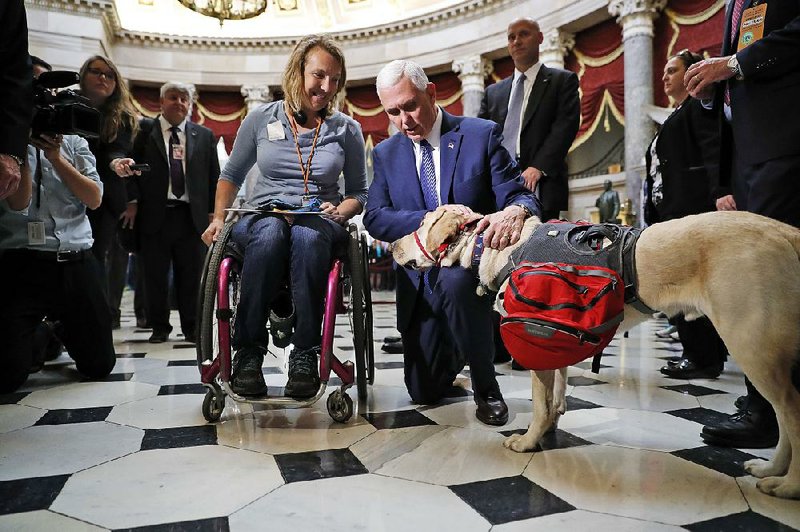 Vice President-elect Mike Pence greets tourist Christine Slavin of Ipswich, Mass., and her dog Earle on Thursday in Statuary Hall on Capitol Hill.