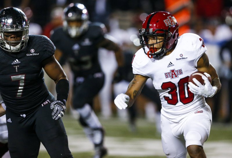 Arkansas State running back Johnston White (30) tries to get around Troy defensive end Rashad Dillard (7) during the first half of an NCAA college football game, Thursday, Nov. 17, 2016, in Troy, Ala. (AP Photo/Butch Dill)
