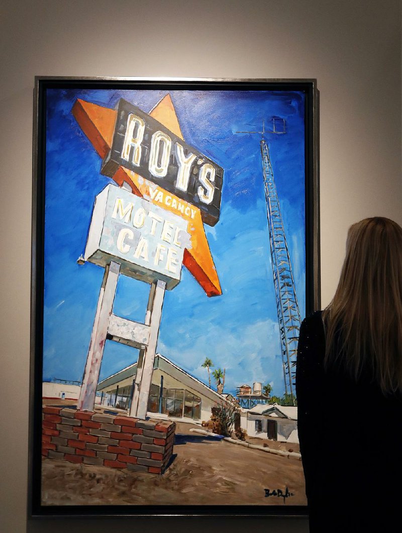 A woman looks toward a Bob Dylan painting titled Abandoned Motel, Eureka. It is part of a show of Dylan’s paintings at London’s Halcyon Gallery in “The Beaten Path” exhibit.
