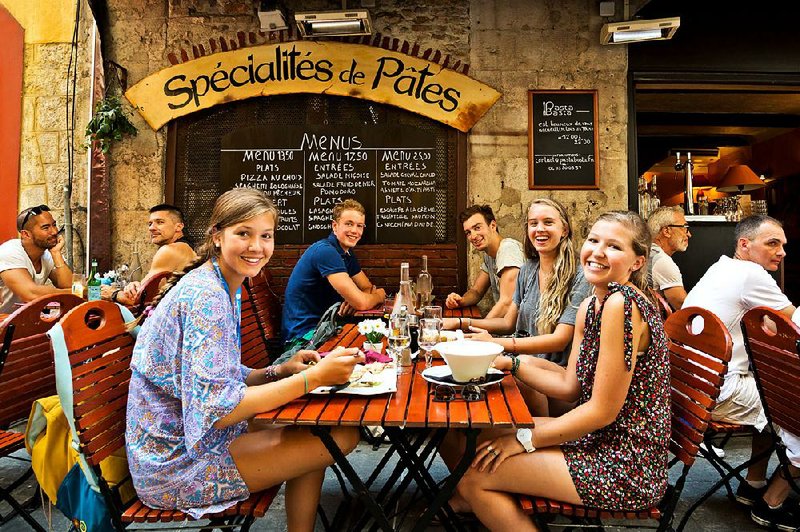 Locals are eager to share their culture with an approachable traveler, such as at this “meet-up” dinner in Nice, France.