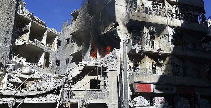 Smoke rises and fires burn after airstrikes on Friday hit the Al-Shaar neighborhood of Aleppo, Syria.

