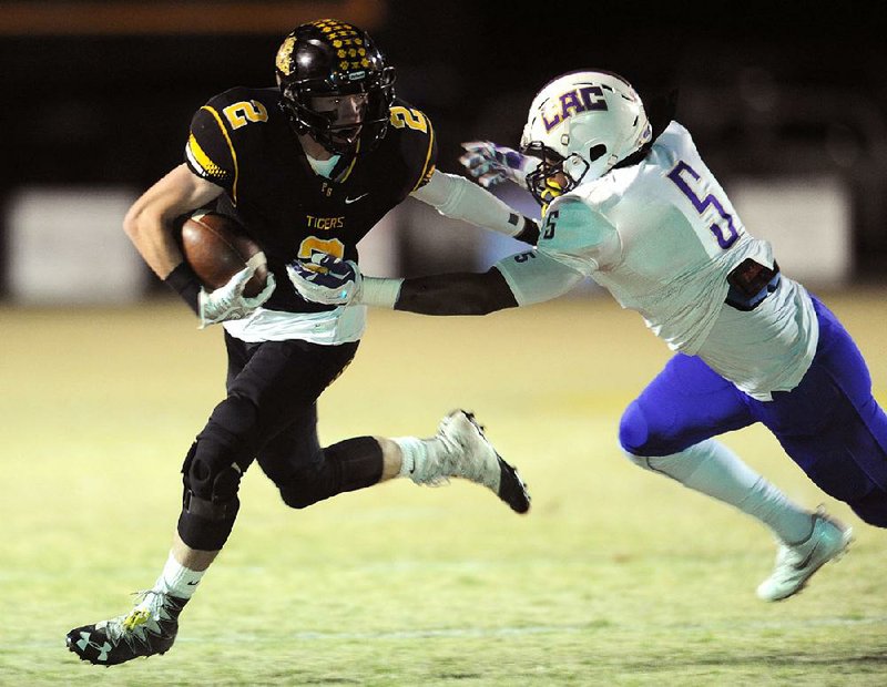 Prairie Grove receiver Isaac Disney (left) shoves off Central Arkansas Christian defender Kyvin Carroll in the first half of Friday’s Class 4A second-round game. The Tigers opened up a 28-point halftime lead and rolled to a 61-13 victory.