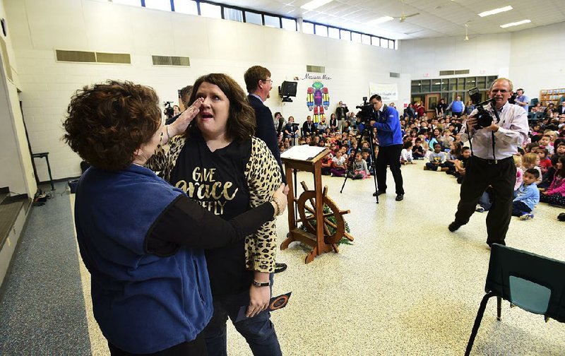 Kara Davis, a fourth-grade teacher at Mathias Elementary School in Rogers, gets a hug from Principal Betsy Kinkade after Davis learned she was one of 35 people in the U.S. to receive this year’s Milken Educator Award.