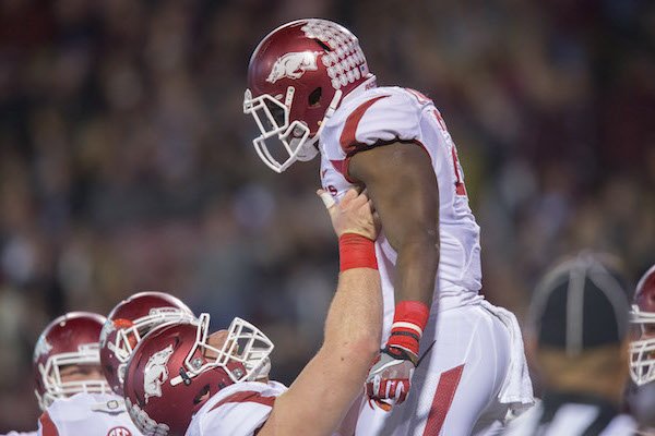 Arkansas offensive lineman Frank Ragnow (72) lifts running back Rawleigh Williams (22) in celebration following a touchdown by Williams against Mississippi State on Saturday, Nov. 19, 2016, at Davis Wade Stadium in Starkville, Miss., during the first quarter