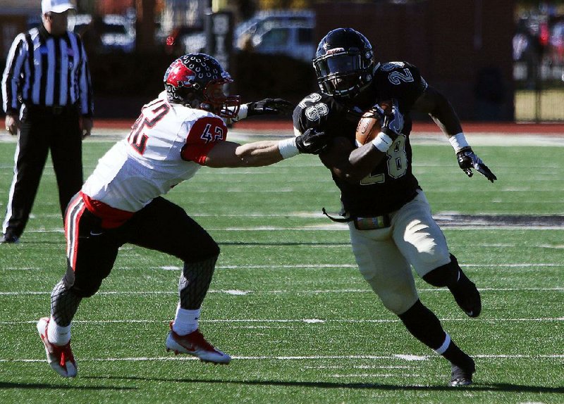 Harding running back Zach Shelley (right) tries to avoid Central Missouri defensive back Jackson Newman in Saturday’s NCAA Division II playoff game at First Security Stadium in Searcy. The Bisons finished with 355 yards rushing to beat the Mules 48-31.