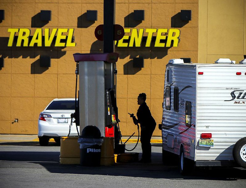 A traveler pulling a trailer with an Alabama license plate fi lls up Saturday at a Pilot Travel Center off Interstate 40 in North Little Rock. Highways and airports are starting to fi ll up with Thanksgiving travelers.