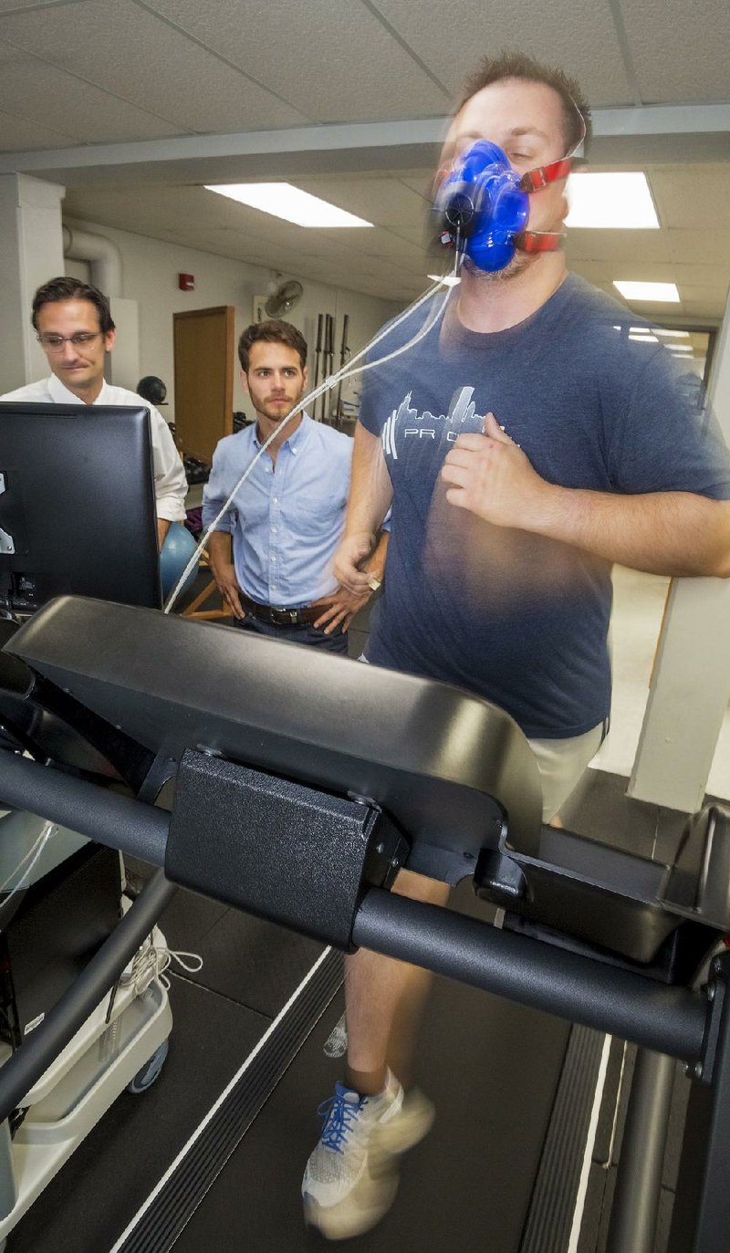 Volunteer Zack Damon runs on a treadmill to demonstrate a metabolic test at the University of Central Arkansas
Human Performance Laboratory, while associate professor Michael Gallagher (far left) and student assistant Nathan King monitor his progress.