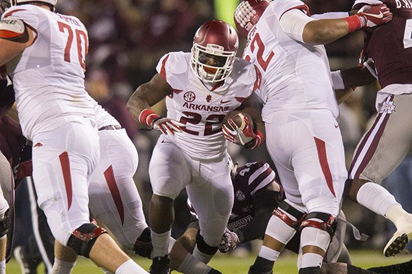 Arkansas running back Rawleigh Williams runs through a hole as offensive linemen Dan Skipper (70) and Frank Ragnow (72) block during a game against Mississippi State on Saturday, Nov. 19, 2016, in Starkville, Miss. 
