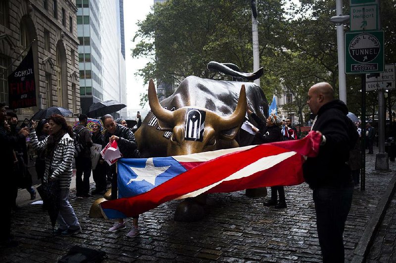 Protesters hold a Puerto Rican flag at the Charging Bull sculpture in New York City during a demonstration in September. Puerto Rico’s governor on Monday rejected a federal control board’s request that he submit an amended fiscal plan for the U.S. territory.